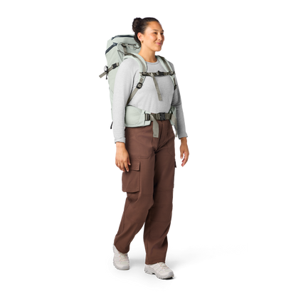 Person wearing a backpack and brown pants on a white background