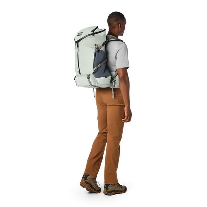 Person wearing a large backpack on a white background